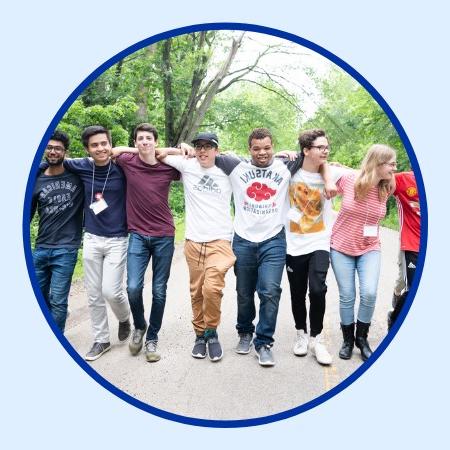 Group of teens arm-in-arm walking across a road